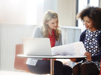 Two Professional Women Looking A Documents