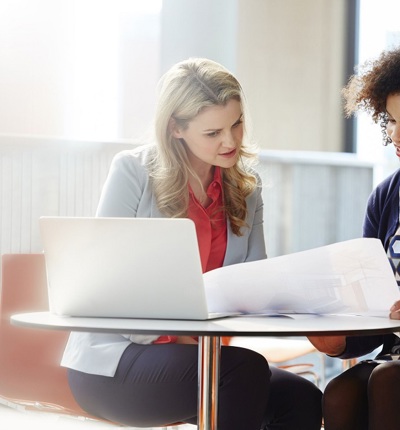 Two Professional Women Looking A Documents