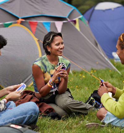 Group Of Young Adults At Campsite Playing Cards